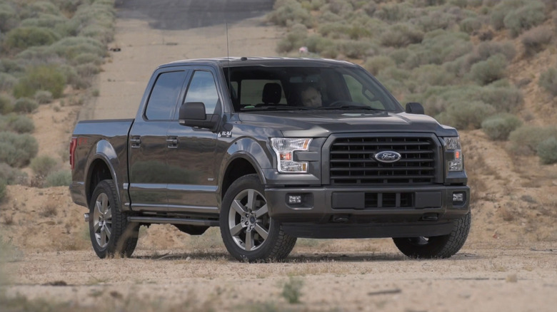 A side on shot of a gray 2015 Ford F-150 parked on a trail