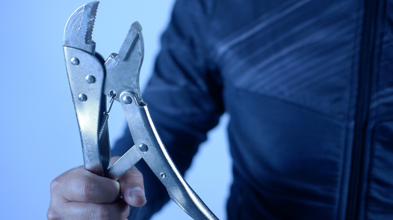 hand holding locking mole grip pliers