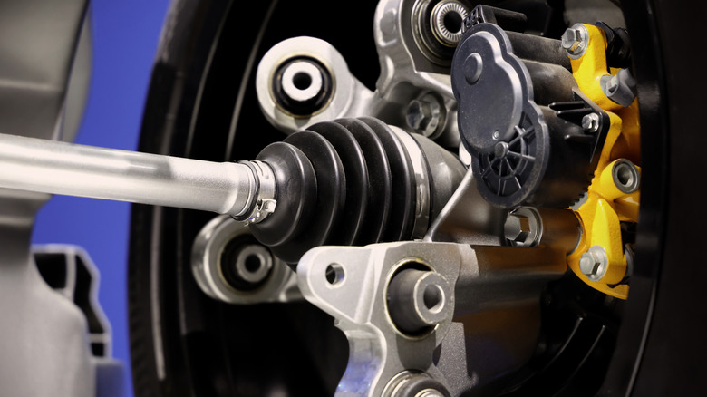 Parts of a car behind the wheel, including brake calipers and CV axle