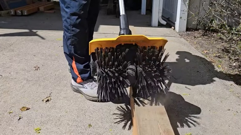 Person using DeWalt powered sweeper