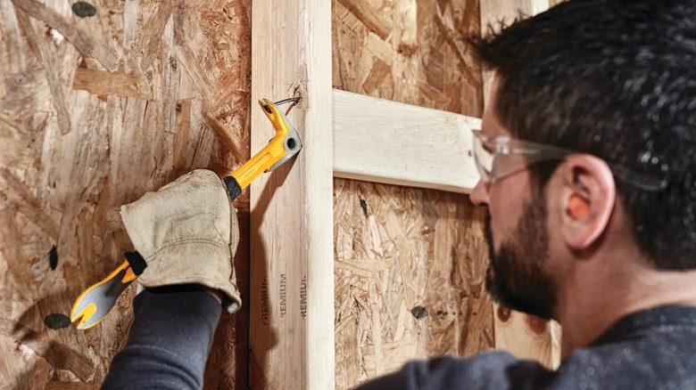 Person using DeWalt claw bar