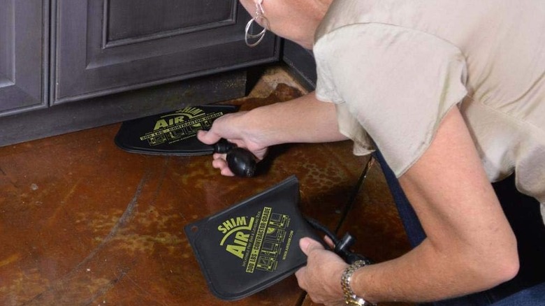 A woman slipping an Air Shim into a small gap.