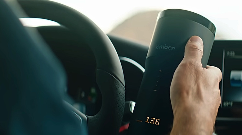 A driver holding an Ember Mug² in his car.