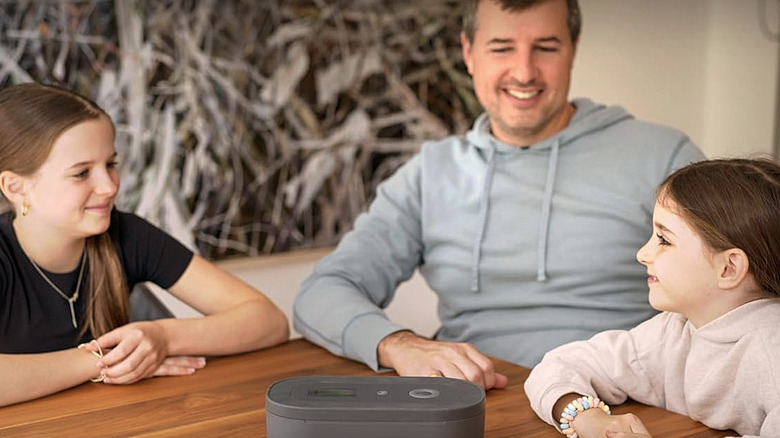 A family happy ans sitting around a Mindsight Phone Lock Box on the table.