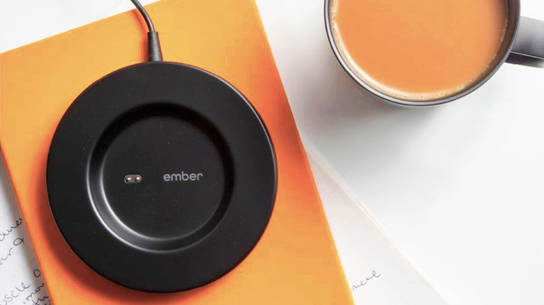 The Ember Mug² charging plate next to coffee in the mug.