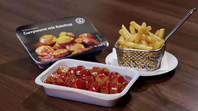 A basket of fries with Volkswagen Currywurst covered in ketchup