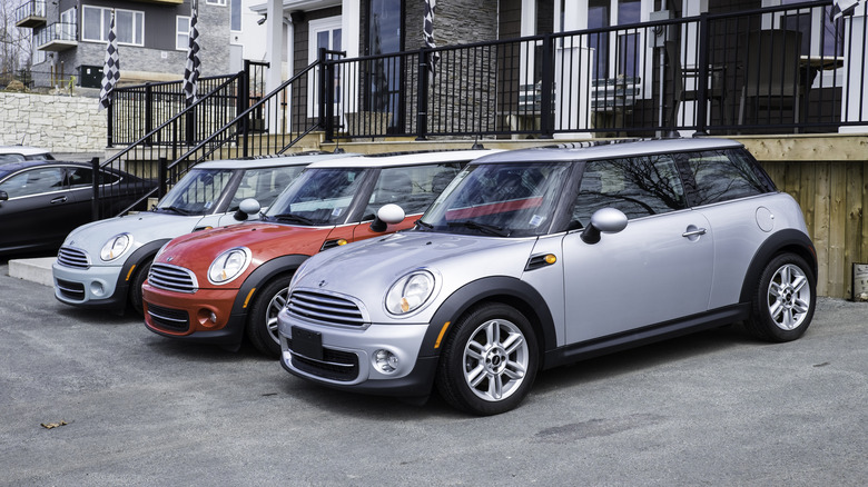 Three Mini Coopers lined up side by side outside a house in Halifax.