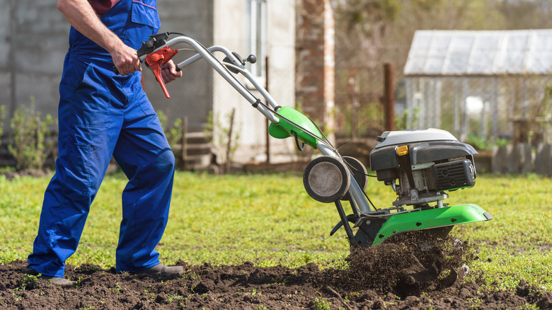 man using power tiller before planting crops