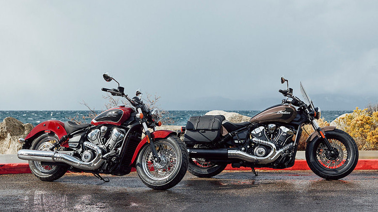 Two Indian Super Scout motorcycles parked next to each other on ashpalt, each in a different color scheme.