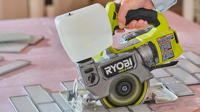 A person using a Ryobi tile saw to cut tile