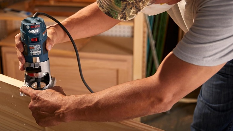 person using Bosch palm router