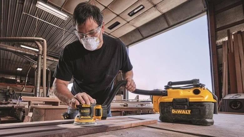 man using DeWalt orbital sander