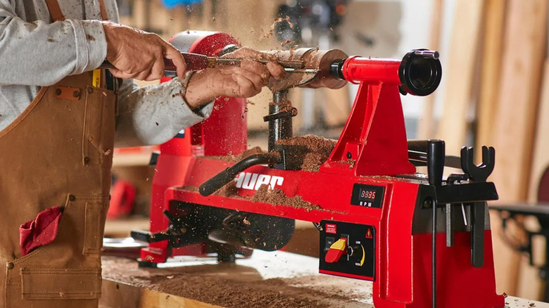 A woodworker shaping a piece of wood on a Bauer lathe.