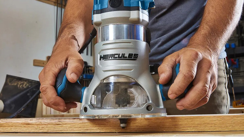 A man using a Hercules router to cut a channel into some wood
