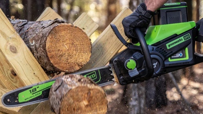 Person using Greenworks electric chainsaw
