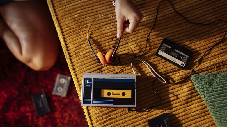 A cassette player with headphones nearby on a plush surface