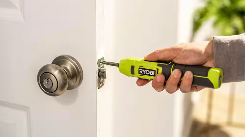 Fastening a screw in a door lock with a Ryobi screwdriver