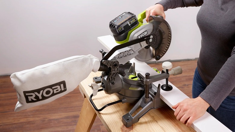 Person using Ryobi compound miter saw