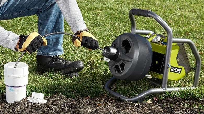 Person using Ryobi drain auger