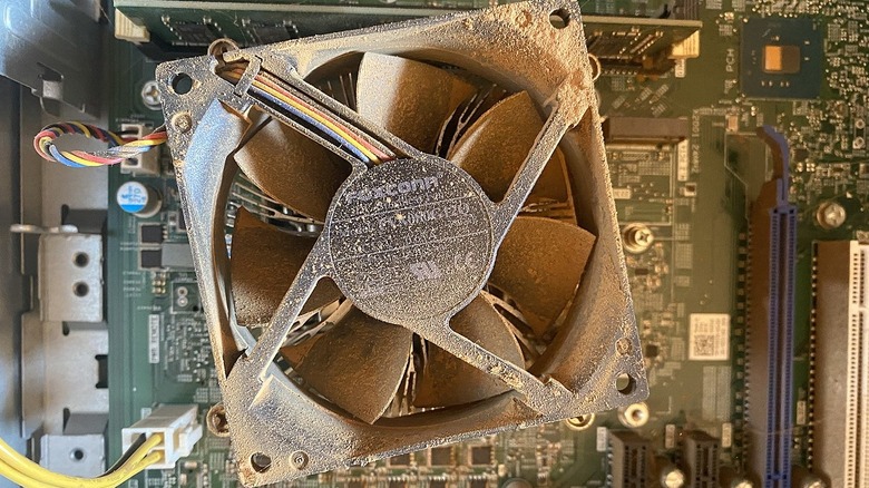 Dusty computer fan on top of the computer motherboard