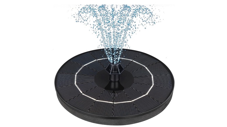 A black fountain spraying water against a white backdrop