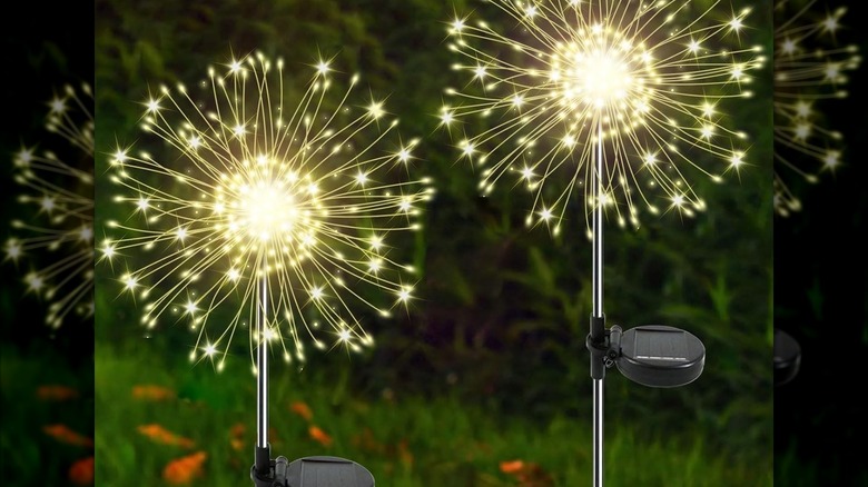 Two lights resembling starbursts on ground stakes with solar panels