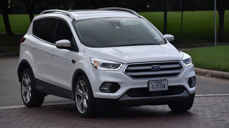 A white Ford Escape merging onto a road