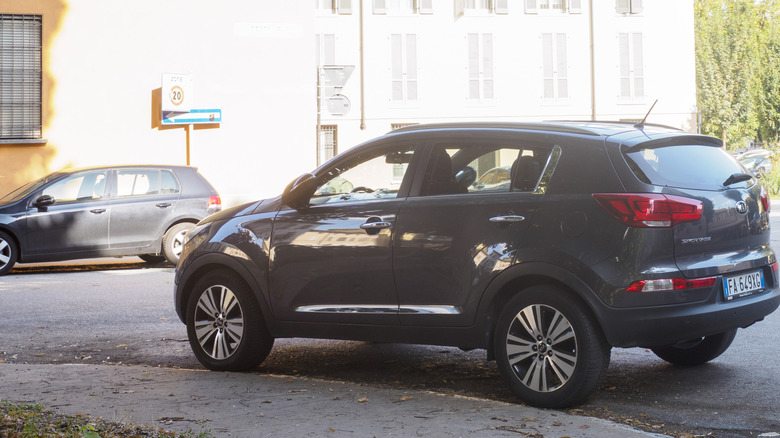 A silver Kia Sportage parked in the shade