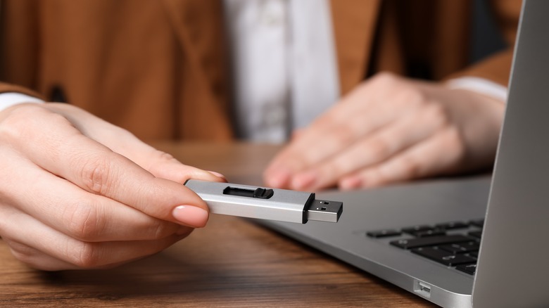 A woman holding a flash drive