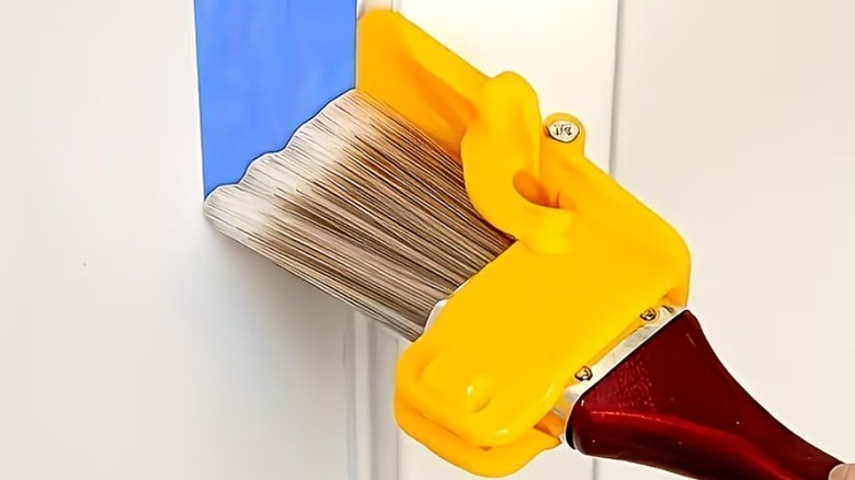 Paintbrush with plastic edge guard