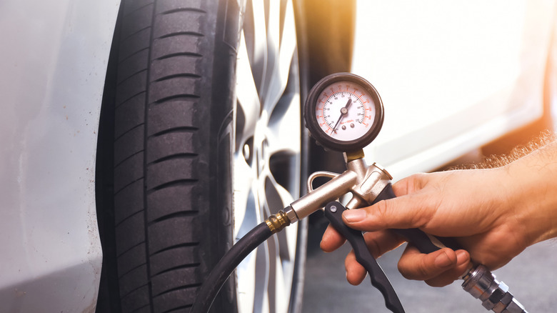 A man inflating the tire of a car