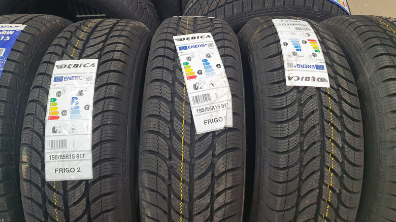 Close-up of several Debica Frigo 2 winter tires on display, each labeled with EU energy and performance rating stickers.