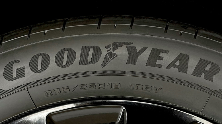Close-up of a Goodyear tire showing the brand name, winged foot logo, and tire size information (235/55R19 105V) on the sidewall.