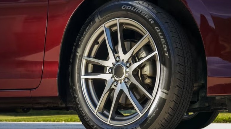 Close-up of a Mastercraft Courser Quest tire mounted on a modern alloy wheel, fitted to a red vehicle parked on a paved surface.