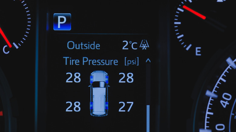 A close up shot of a car's driver information display, showing the air pressure in the four tires.