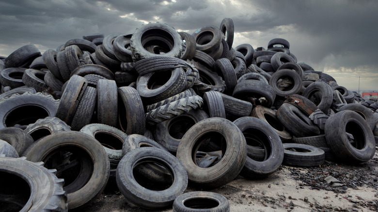 A pile of old, discarded tires in an industrial landfill.