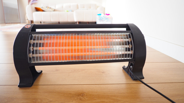 A portable space heater on a wooden floor