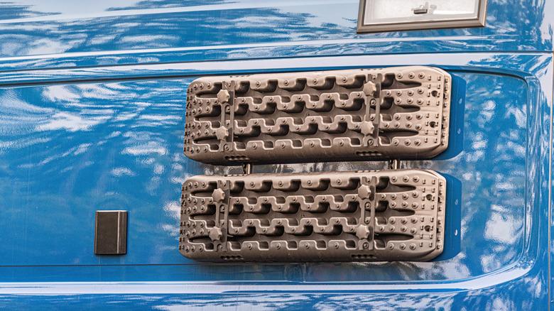Two sets of traction mats on the back of a pickup van
