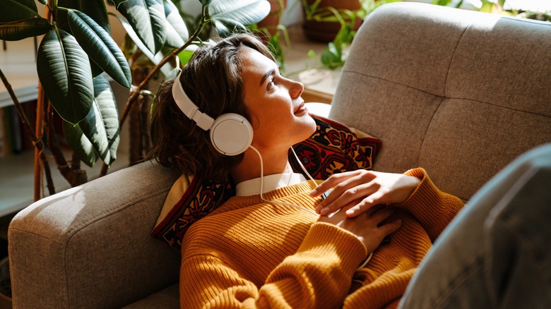 woman on sofa listening to music