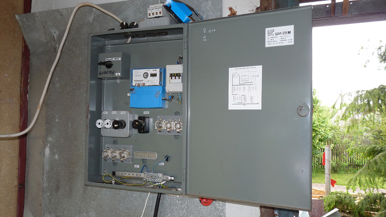 A breaker box placed on the wall of a garage