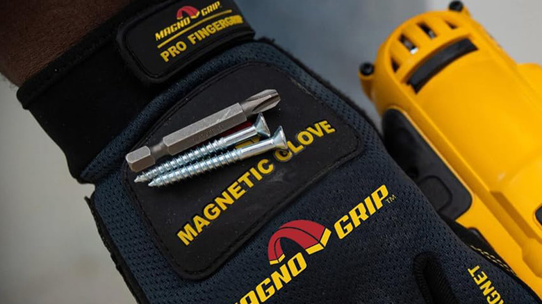 A worker using a glove with a magnet that holds screws