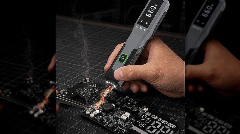 Using a soldering iron on a circuit board.