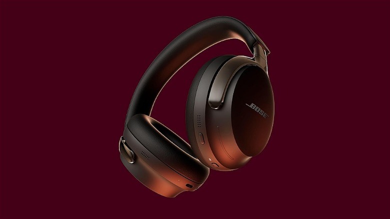 Wireless Bose headphones against a maroon background.