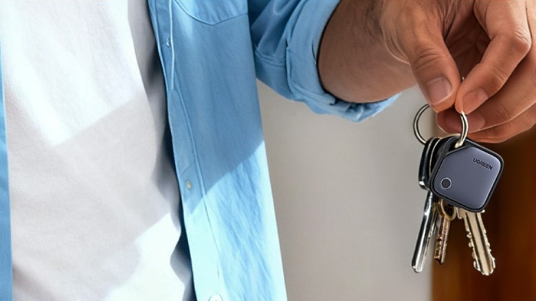 Man holding keys with an air tracker attached to the key ring.