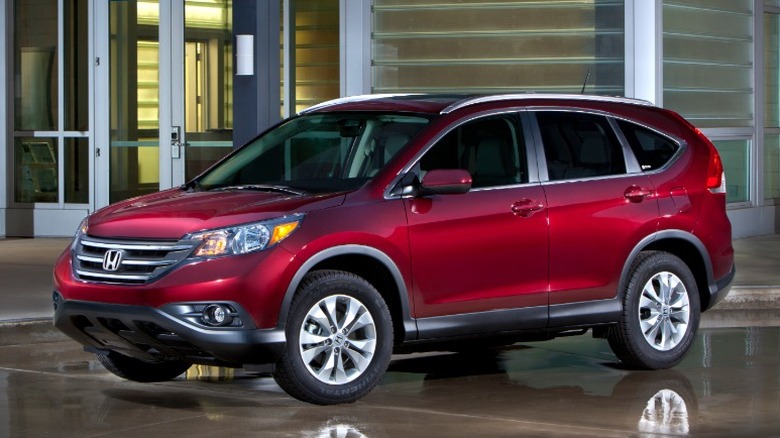 Red 2012 Honda CR-V parked on wet concrete in front of a building at night