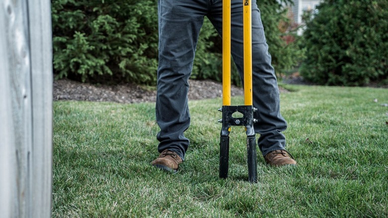 Person using DeWalt post hold digger