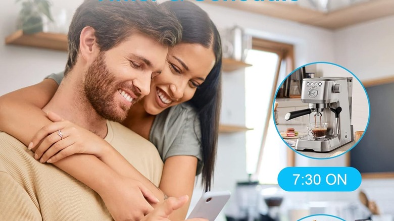 A couple looking down as a coffee maker makes coffee.