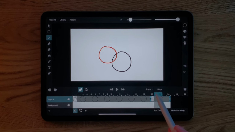 a person using the ToonSquid app with an Apple Pencil, with an iPad resting on a table