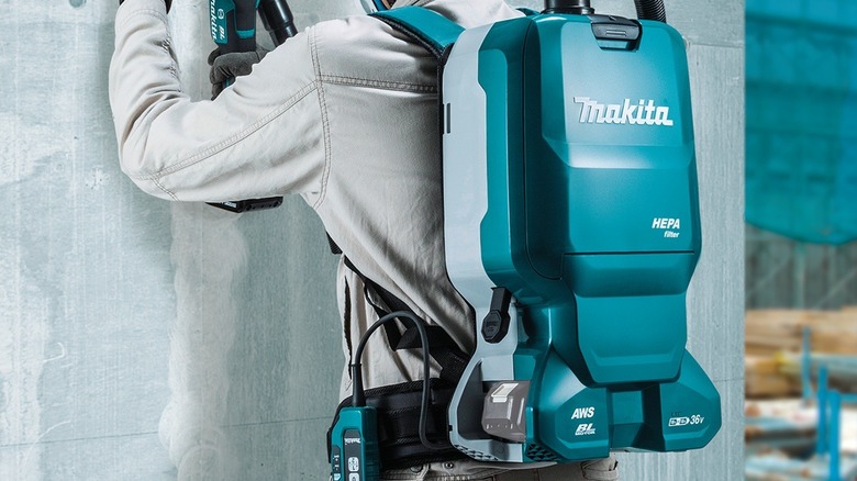 Person wearing backpack dust extractor