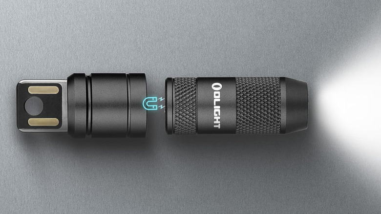 An Olight-brand flashlight and its USB charge base next to each other